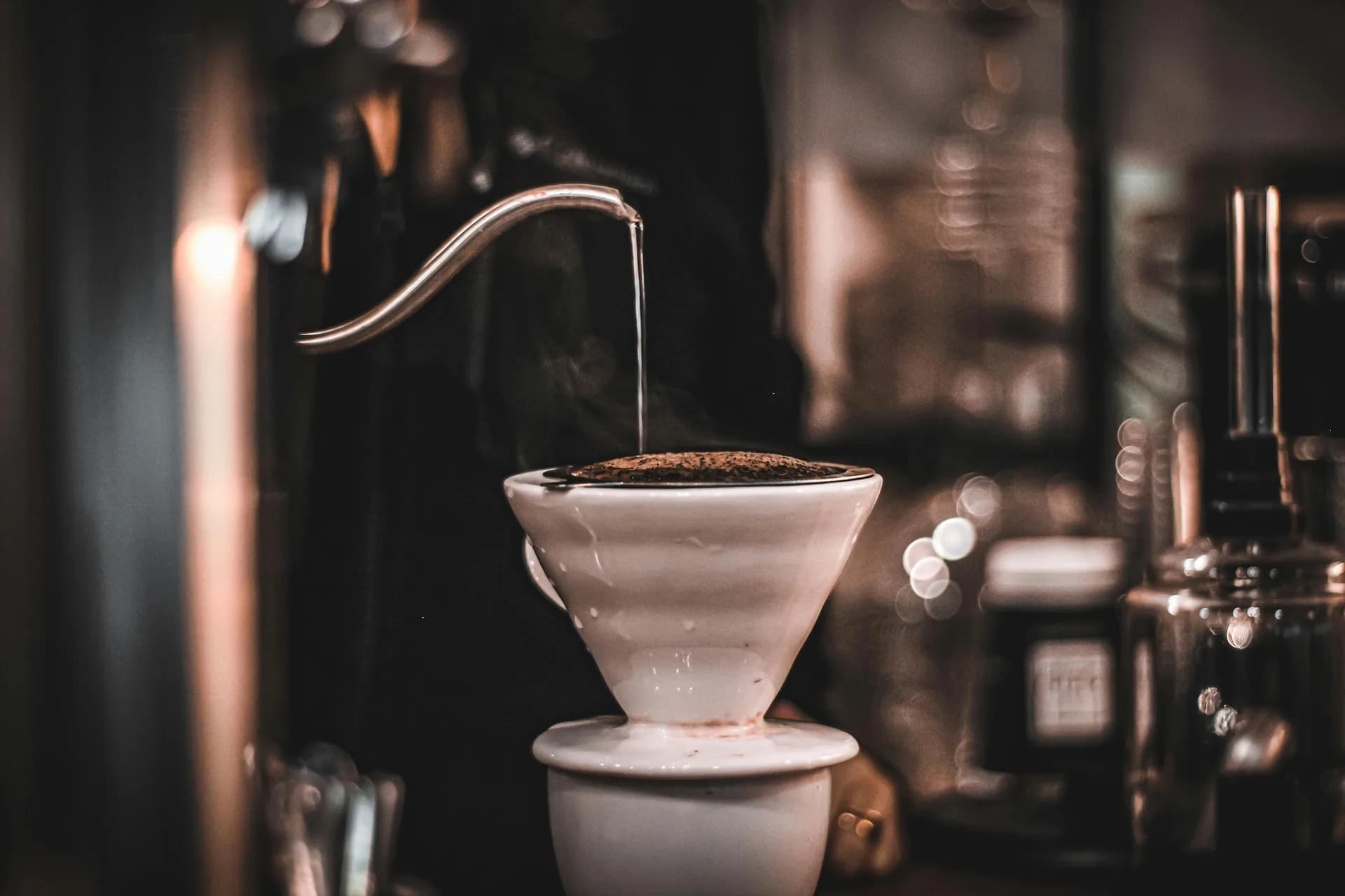 A gooseneck kettle and ceramic pour-over brewer ready for coffee service